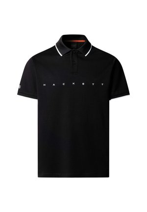 Polo negro de manga corta con ribete blanco en el cuello y los puños, con el texto "HACKETT" en el pecho y un pequeño logo en la manga izquierda.