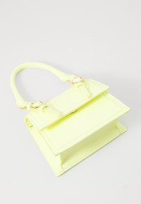 Sac à main en similicuir jaune fluo avec un design structuré, une poignée supérieure, des accents de quincaillerie dorée et une fermeture rabat.