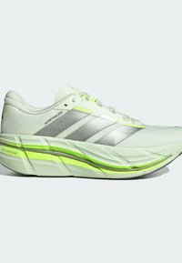 Chaussure de course Adidas blanche et vert néon avec des bandes argentées, une semelle épaisse et rembourrée, et le texte « DREAMSTRIKE » près du talon.