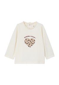 Cremfarbendes Langarmshirt mit einem Rüschenausschnitt und einem Herzgrafik mit braunen Leoprintflecken und rotem Text.