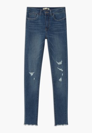 Blå slidte skinny jeans med frynset kant og fem lommer, med subtil falmen og revnede detaljer på begge ben.