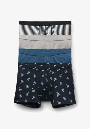 Cuatro bóxers de hombre doblados en rayas negras y blancas, gris sólido, azul sólido y negro con estampados blancos de palmeras.