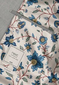 Materiał w kwiatowy wzór w odcieniach niebieskiego i kremowego z czerwonymi akcentami, z metką "next tailoring", rozmiar 40R oraz oznaczeniem "slim fit".
