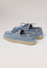 Chaussures en cuir suédé bleu clair avec bouts ronds, laçage sur le devant et semelles en jute tressé. Comprend des œillets et une bordure cousue pour plus de durabilité.