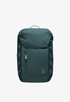 Ciemnozielony prostokątny plecak z przednią kieszenią na zamek, bocznymi pętlami, górnym uchwytem i logo "GOT BAG" w dolnym prawym rogu.