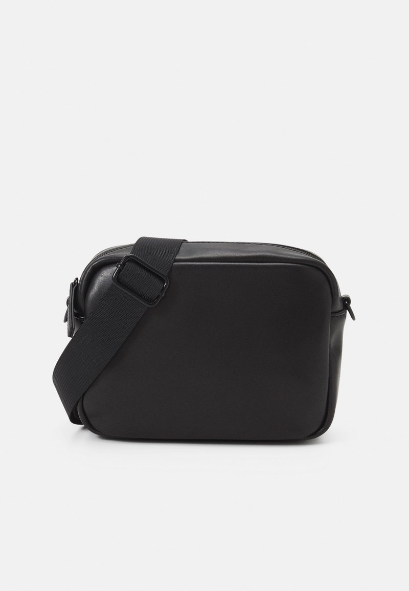 Černá obdélníková kabelka přes rameno vyrobená z hladké kůže, s pevným černým popruhem a zipovým uzávěrem. Minimalistický design bez vzorů.