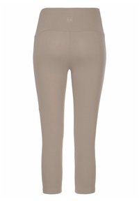 Beige Leggings mit einem breiten Taillenbund, aus glattem Stoff gefertigt. Knöchellang, ohne sichtbare Muster oder Metallteile. Einfaches, figurbetontes Design.