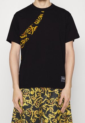 Czarna koszulka z żółtym zdobionym wzorem ułożonym na ukos, wykonana z miękkiej bawełny. Do tego dopasowane szorty z wzorami spiralnymi w kolorze żółtym.