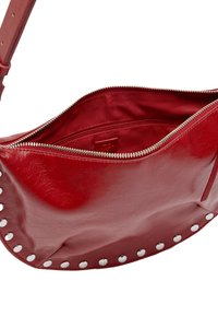 Czerwona skórzana torebka o zaokrąglonym kształcie, z zamknięciem na zamek oraz srebrnymi ćwiekami wzdłuż dolnej krawędzi. Wnętrze wykończone jest gładką podszewką.