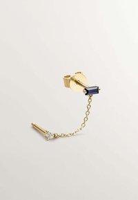 Pendiente de oro con una piedra rectangular azul, conectada por una cadena a un pequeño acento de diamante, que muestra un diseño minimalista.