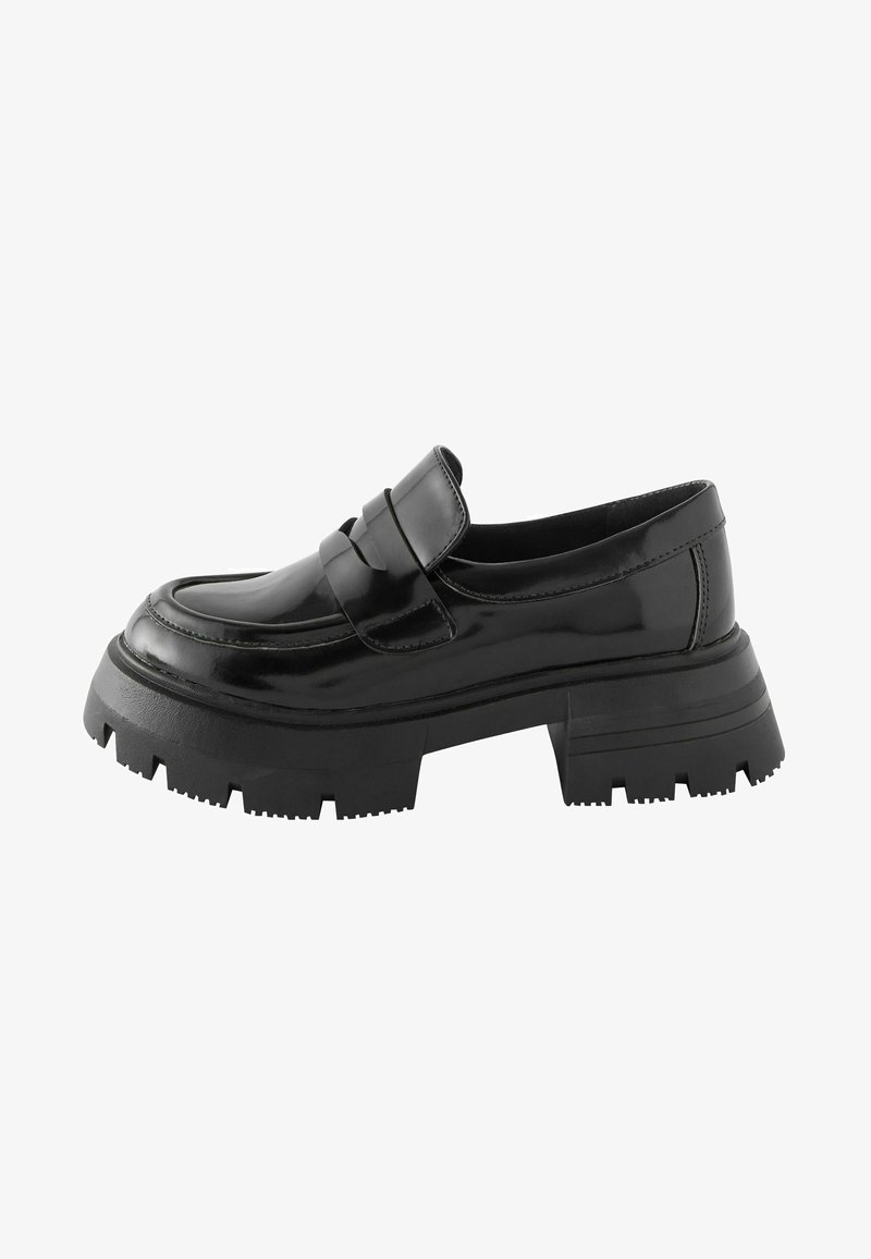 Mustvalged mustad lakknahk loafersid, millel on paks ja tekstureeritud must kummitald ning dekoratiivne riba ees. Sile ja läikiv viimistlus.