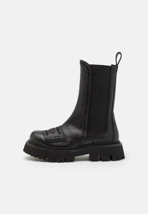 Black leather ankle boots with textured accents, decorative stitching, and a chunky, treaded sole. Features a pull tab for easy wear.
