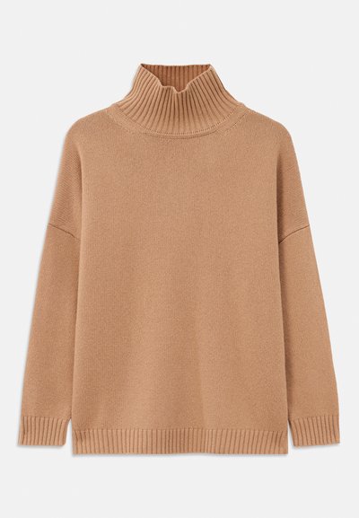 Pull over côtelé beige, au design oversize, avec des épaules tombantes et un tricot texturé. Il présente un ourlet droit et des fentes latérales.