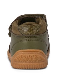 Stivaletto alla caviglia in pelle verde con accenti in suede marrone, cinturino regolabile, tacco testurizzato e suola in gomma con un motivo di tassellatura.