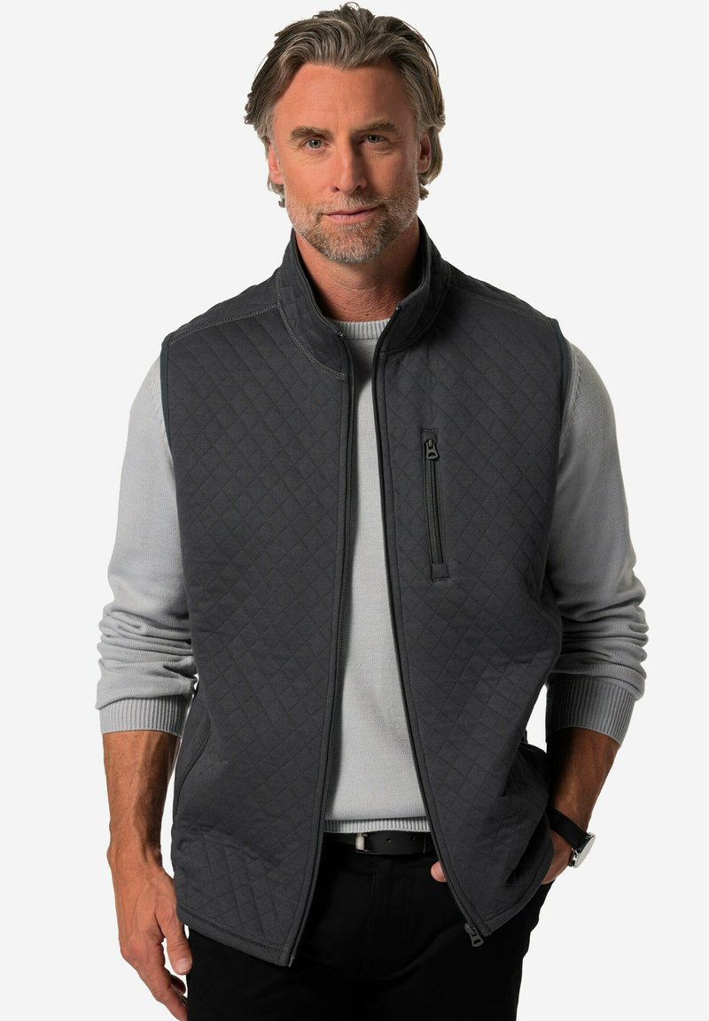 Mörkgrå kviltad väst med hög krage, en dragkedjeförsedd bröstficka och sidofickor, lagrad över en ljusgrå tröja. Slät textur.