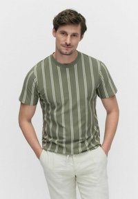 Olijfgroene t-shirt met korte mouwen en witte verticale strepen. Beschikt over een ronde halslijn en een getailleerde pasvorm. Soepele katoenstructuur.