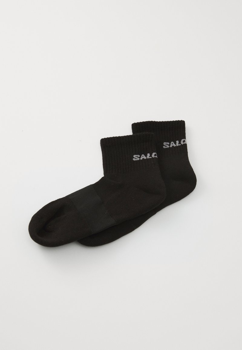 Calcetines de algodón negros hasta el tobillo con puños acanalados, que presentan una punta de tejido plano y un diseño del logo "SAL" en gris en el lado exterior.
