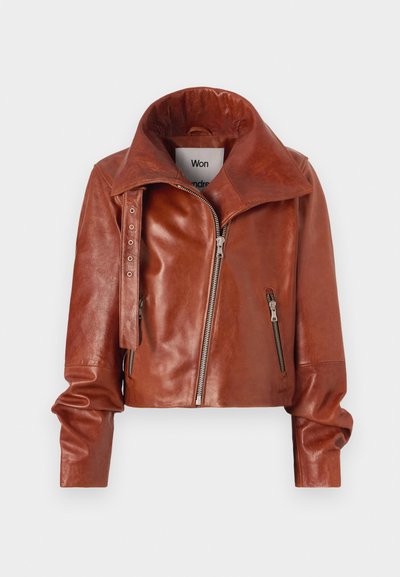 Pruunist nahast lühike jakk kõrge kraega, millel on tõmblukkude sulgemine ja kaarjas disain. Sile tekstuur koos aksessuaaride detailidega.