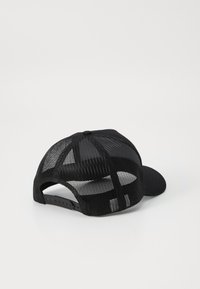 Fekete sapka, amelynek struktúrált eleje és hálós hátsó része van. Lapos karima, textúrált mintázattal. Állítható snapback az biztos illeszkedés érdekében.