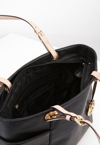 Svart pebbled läder tote-väska med ljusrosa remmar, guldfärgad hårdvara, rymligt inre, ficka med dragkedja och organiseringsfack.