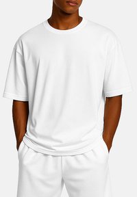 White cotton T-shirt with short sleeves, a crew neck, and a relaxed fit. Smooth texture, no visible patterns or accents.