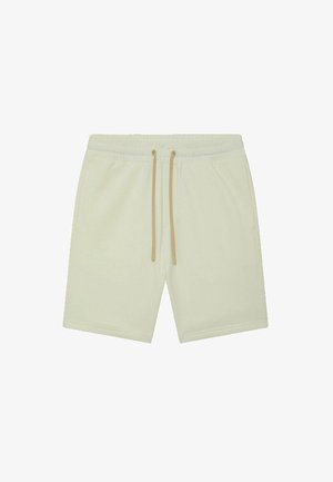 Shorts de sport couleur crème en tissu doux, dotés d'une taille élastique et de cordons beiges. Conçus avec des poches latérales.