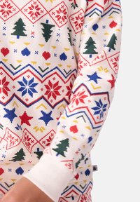 Maglione bianco con un motivo festivo colorato che presenta alberi, fiocchi di neve e forme geometriche in rosso, verde, blu e giallo.