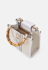 Piccola borsa a tracolla in pelle bianca con tessuto intrecciato beige, dotata di manico in bamboo, hardware dorato e chiusura superiore.