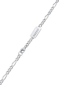 Silverlänkarmband med förlängda ovala länkar, lås och en rektangulär bricka med inskriptionen "Kuzzoí." Mjuk textur och glänsande yta.