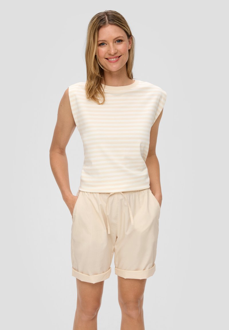 Licht gestreept mouwloos topje in crème en beige, gecombineerd met zachte beige shorts met een trekkoord in de taille en opgerolde mouwen.