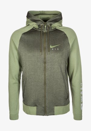 Sweat à capuche zippé avec manches et capuche vert olive, panneau avant plus foncé, logo Nike Air sur la poitrine et texte imprimé sur la manche gauche.