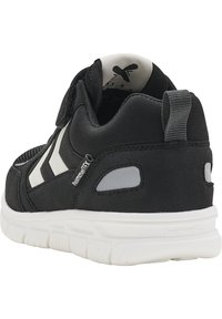 Schwarzer Sportschuh mit weißen Streifen, strukturiertem Stoff, gepolstertem Kragen und Gummisohle; verfügt über eine Ziehlasche an der Ferse und reflektierende Akzente.