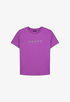 T-shirt di cotone viola con un design frontale di cinque fiocchi delineati da paillettes argentate. Maniche corte e scollatura rotonda.