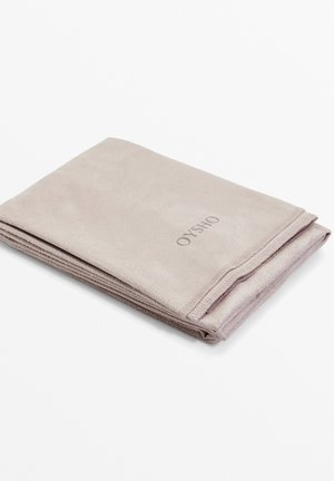 Puha, hajtogatott törülköző világos taupe színű anyagból. Simasággal jellemezhető, és varrott széle van. A "OYSHO" logó sötétszürke színben van nyomtatva.