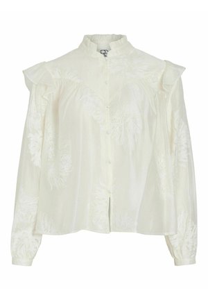 Blusa blanca con un cuello alto, patrones florales bordados, cierre de botones en la parte frontal y mangas abullonadas. Fabricada con un tejido ligero y texturizado.