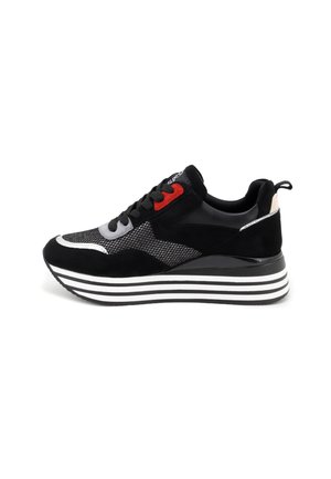 Sneaker sportivo nero con upper in mesh e suede, dettagli rossi e grigi, suola spessa a strisce e lacci neri. Presenta una linguetta posteriore.