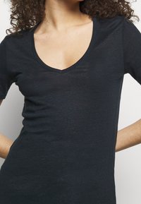 Black short-sleeve V-neck t-shirt made of lightweight fabric, featuring a fitted silhouette and smooth texture. No visible patterns or accents.