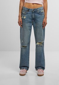 Light blue denim wide-leg jeans with distressed detailing, featuring two knee rips and a classic five-pocket design.