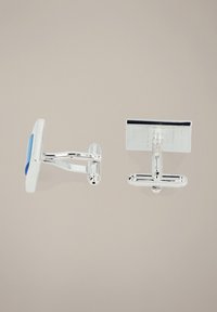 Srebrne spinki do mankietów mają prostokątny kształt, z niebieskim akcentem na jednej i teksturowaną powierzchnią na drugiej. Posiadają gładkie krawędzie oraz metalowe zapięcia.