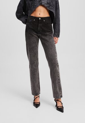 Vaqueros de mezclilla negros de cintura alta con corte recto, que presentan un ligero desgastado, costuras en contraste y diseño de cinco bolsillos.