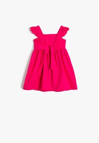 Roze mouwloze jurk met ruches aan de schouderbanden, een nauwsluitende taille en een strikceintuur. Uitlopende rok die boven de knie komt. Gladde textuur.