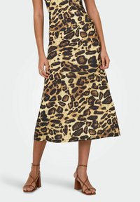 Leopardmønstret midi-kjole i beige og brune nuancer, med en tætsiddende top og flagrende nederdel, parret med brune blok-hælede sandaler.
