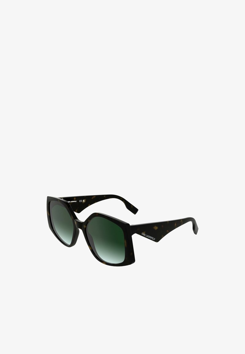 Zonnebril met een octagonale montuur in zwart en schildpadpatroon, uitgerust met donker groene gradient lenzen en slanke pootjes.