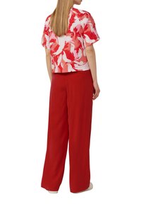 Red floral patterned cropped top paired with wide-leg red pants. Lightweight fabric with subtle texture and relaxed fit.
