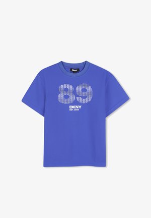 T-shirt à manches courtes bleu DKNY avec texte blanc "DKNY EST. 1989" et grand logo "DK" composé de répétitions du texte "NEW YORK" sur le devant.