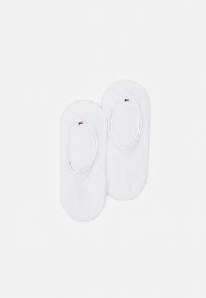 White cotton no-show socks featuring a rounded toe, elastic openings, and a small logo accent on the side. Soft texture and lightweight design.