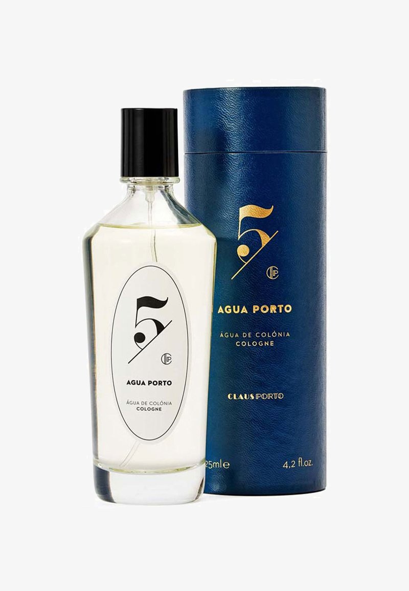 Bouteille en verre transparent avec un capuchon noir, portant une étiquette blanche avec du texte noir. Accompagnée d'une boîte cylindrique bleue avec des accents dorés.