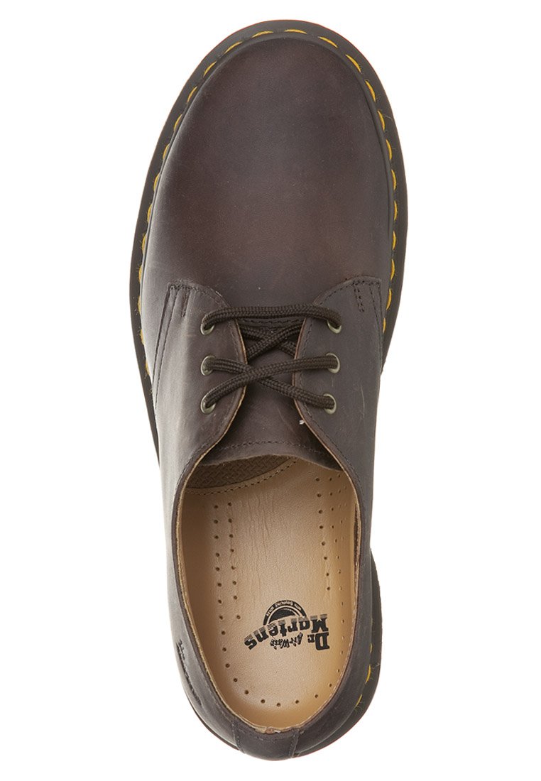 Brown leather shoe with a rounded toe, featuring a lace-up closure, yellow stitching along the outsole, and a cushioned insole.