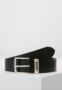 Zwarte leren riem met een zilveren metalen gesp. Kenmerkt zich door een strak ontwerp en reliëfbranding op de gesp. Soepele textuur en schone randen.