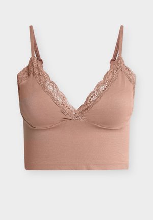 Soutien-gorge brassière rose pâle avec bordure en dentelle sur les bonnets, bretelles fines réglables et bande en tissu lisse et sans coutures sous la poitrine.